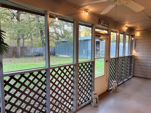 unfurnished sunroom with ceiling fan