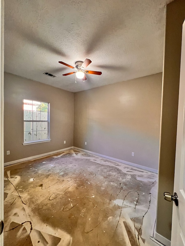 empty room featuring ceiling fan and a textured ceiling