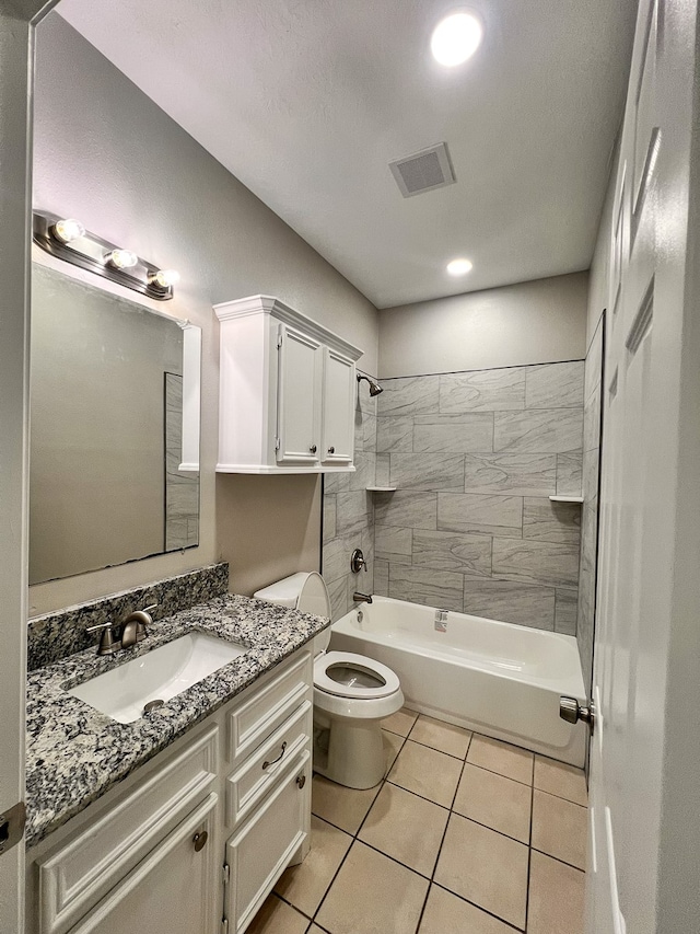 full bathroom with tile patterned floors, vanity, a textured ceiling, tiled shower / bath combo, and toilet