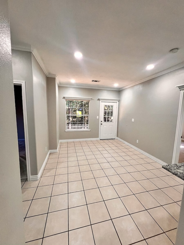 tiled spare room featuring crown molding