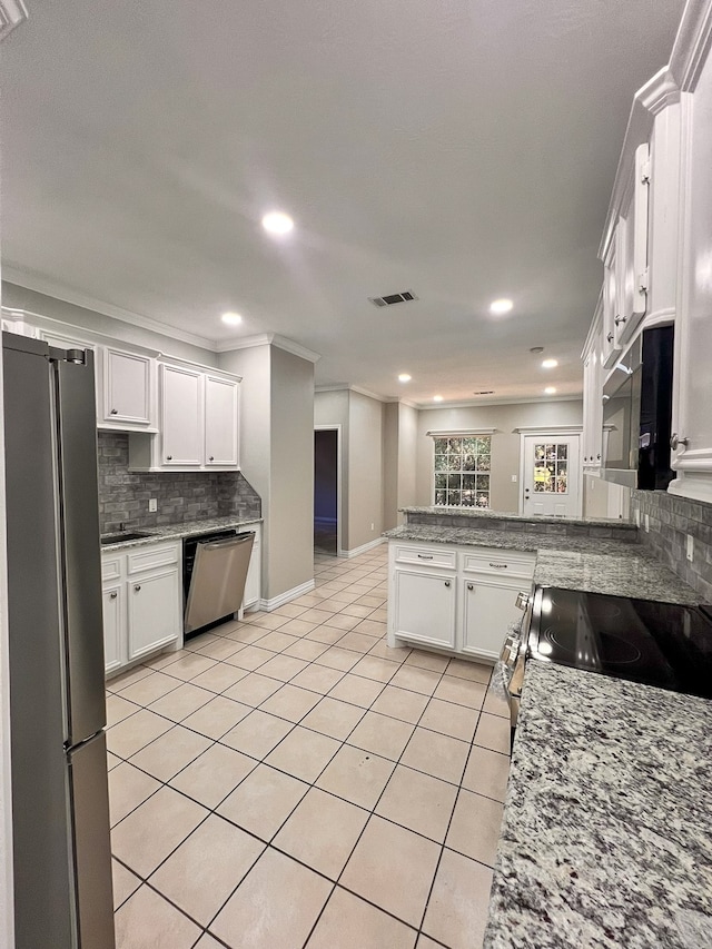 kitchen featuring stainless steel appliances, tasteful backsplash, light stone counters, kitchen peninsula, and white cabinets