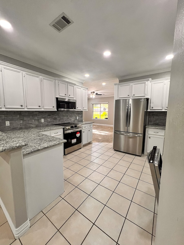 kitchen with light tile patterned flooring, decorative backsplash, white cabinets, and stainless steel appliances