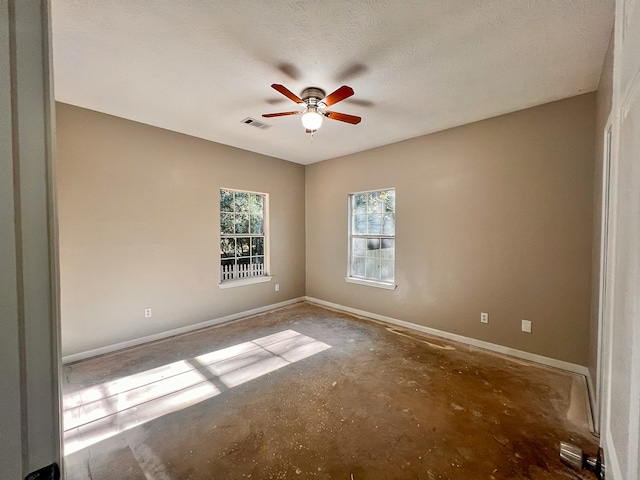 unfurnished room with ceiling fan, a textured ceiling, and concrete floors