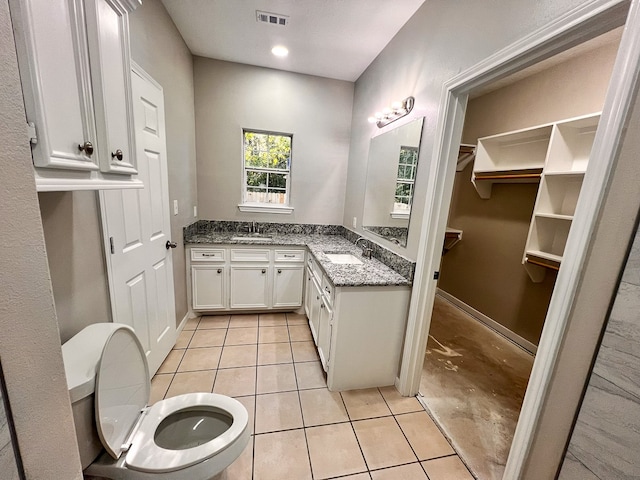 bathroom with tile patterned flooring, vanity, and toilet