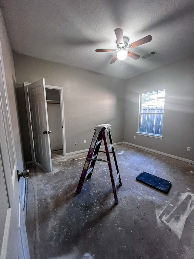 unfurnished bedroom with ceiling fan and a textured ceiling