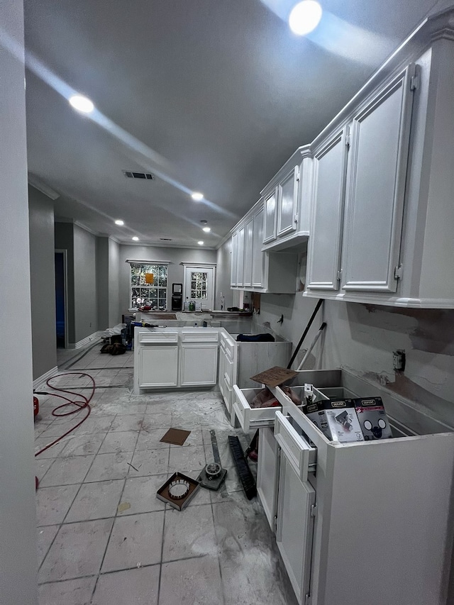 kitchen with kitchen peninsula, white cabinets, and white range