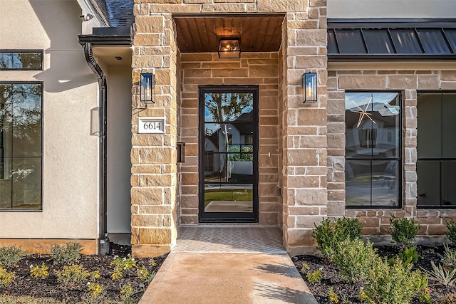 property entrance featuring stucco siding and stone siding