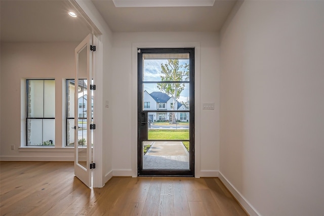 doorway with light wood-style flooring and baseboards