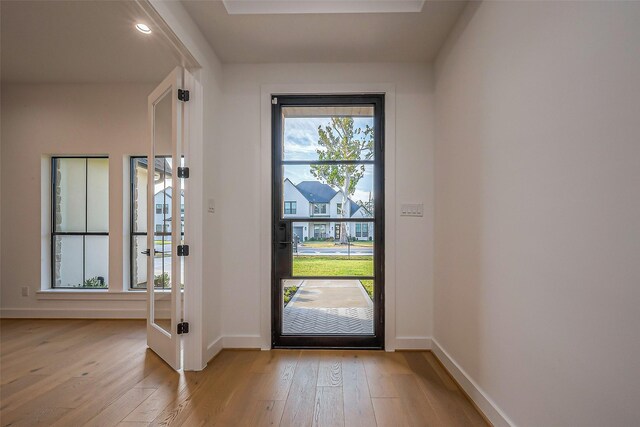doorway featuring baseboards and wood-type flooring