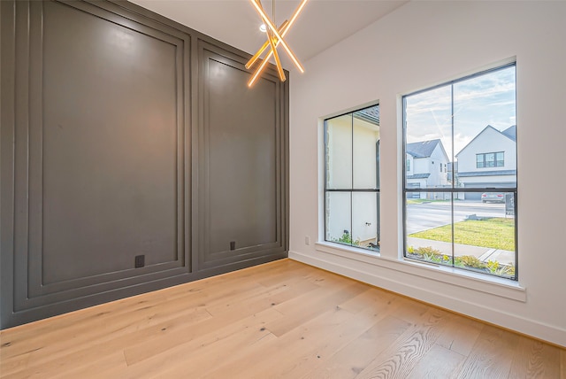 spare room featuring light wood-type flooring and plenty of natural light