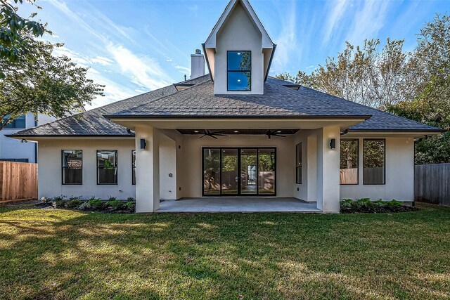 back of house with fence, stucco siding, a lawn, a ceiling fan, and a patio