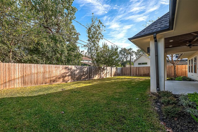view of yard with a fenced backyard, a ceiling fan, and a patio area