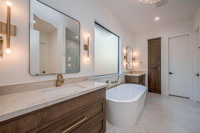 bathroom with visible vents, a sink, a freestanding bath, and two vanities