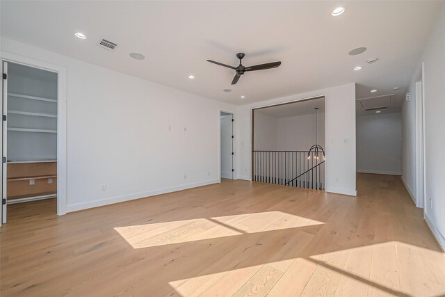 unfurnished bedroom featuring a walk in closet, visible vents, baseboards, recessed lighting, and light wood-style flooring