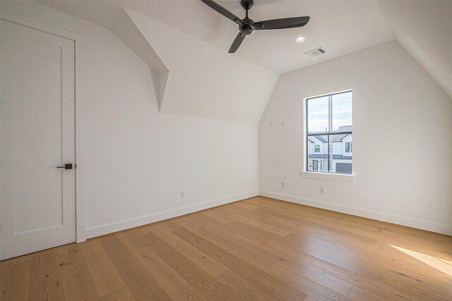 bonus room with baseboards, visible vents, lofted ceiling, and light wood-style floors