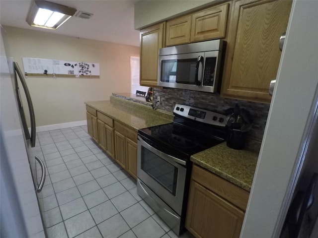 kitchen featuring stainless steel appliances, light tile patterned floors, and tasteful backsplash