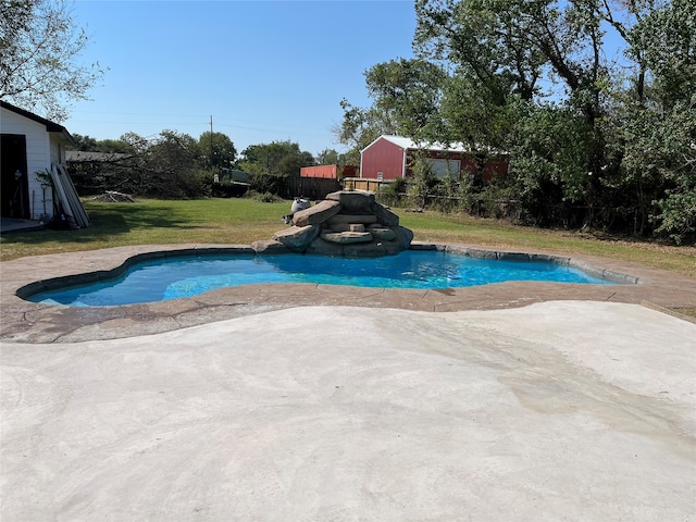 view of swimming pool featuring a patio, a storage shed, and a lawn