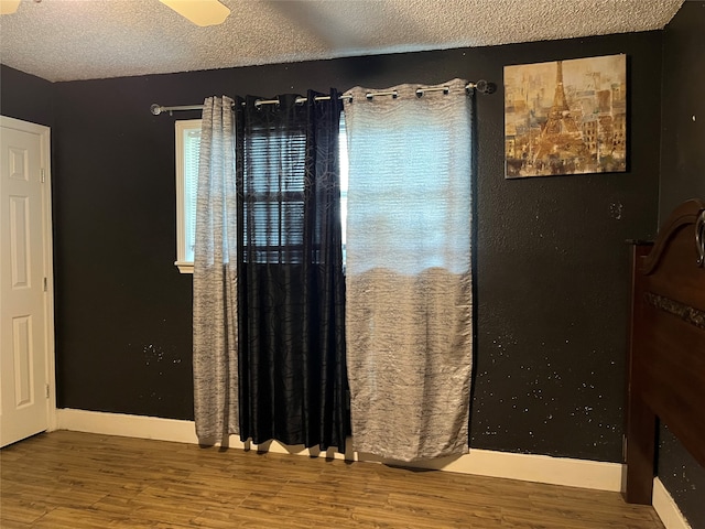 bedroom with hardwood / wood-style floors and a textured ceiling