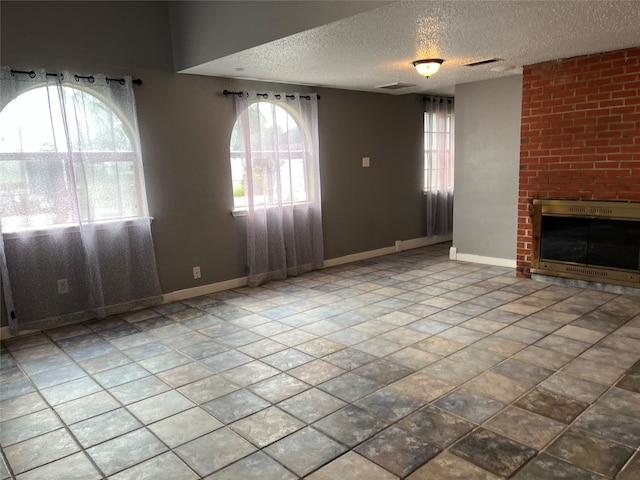 unfurnished living room featuring a fireplace and a textured ceiling