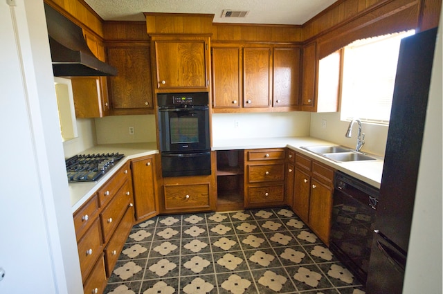 kitchen featuring extractor fan, a textured ceiling, black appliances, and sink