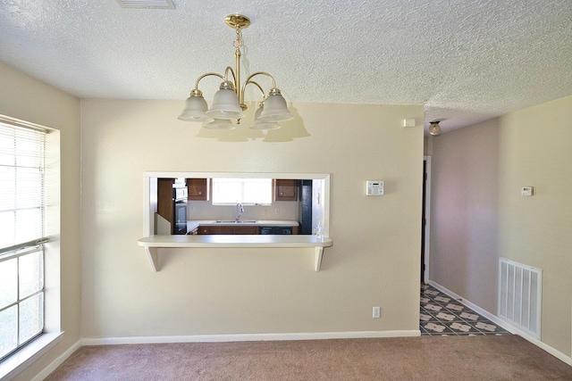 kitchen featuring a textured ceiling, a chandelier, carpet flooring, pendant lighting, and sink