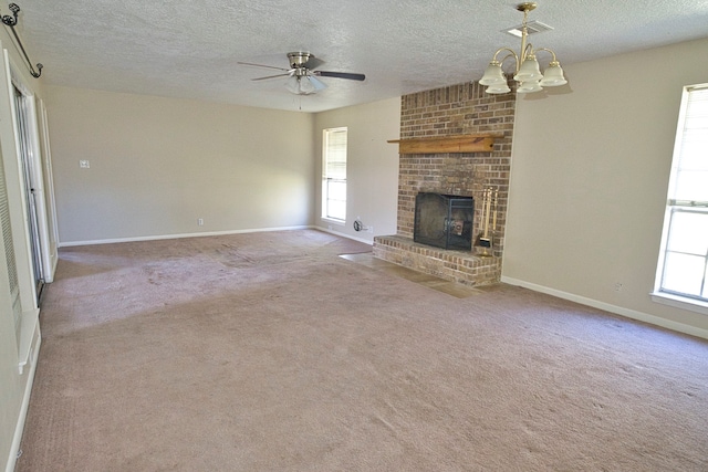 unfurnished living room featuring light carpet, a textured ceiling, a wealth of natural light, and a fireplace