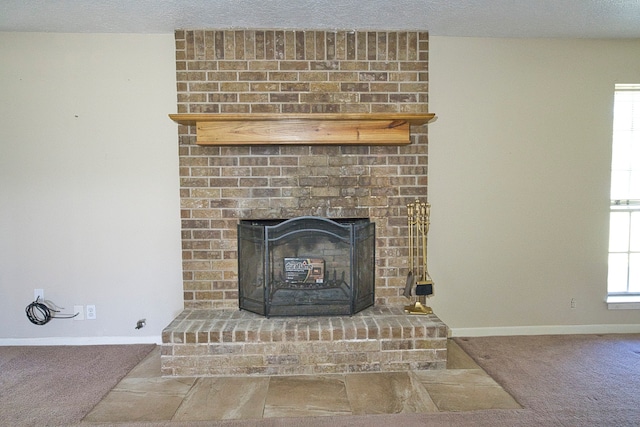 room details featuring a textured ceiling, carpet flooring, and a fireplace