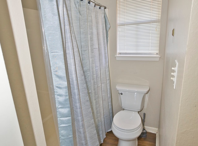 bathroom featuring toilet, wood-type flooring, and a shower with shower curtain