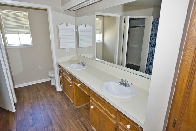 bathroom featuring toilet, curtained shower, hardwood / wood-style flooring, and vanity