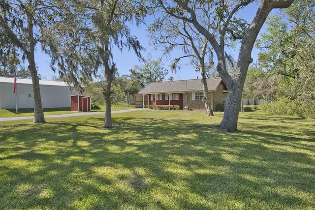 6823 County Road 659, Brazoria, TX 77422 - view of front of house with a front yard and a storage shed