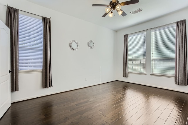 empty room with ceiling fan and dark hardwood / wood-style flooring