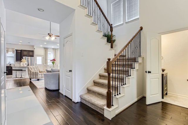 stairs featuring hardwood / wood-style flooring and ceiling fan