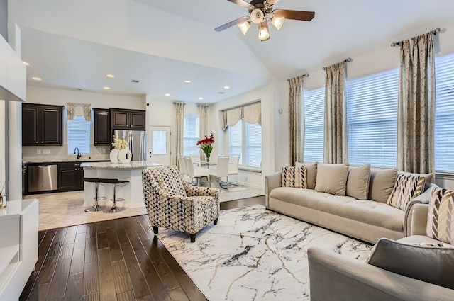 living room featuring sink, vaulted ceiling, light hardwood / wood-style flooring, and ceiling fan