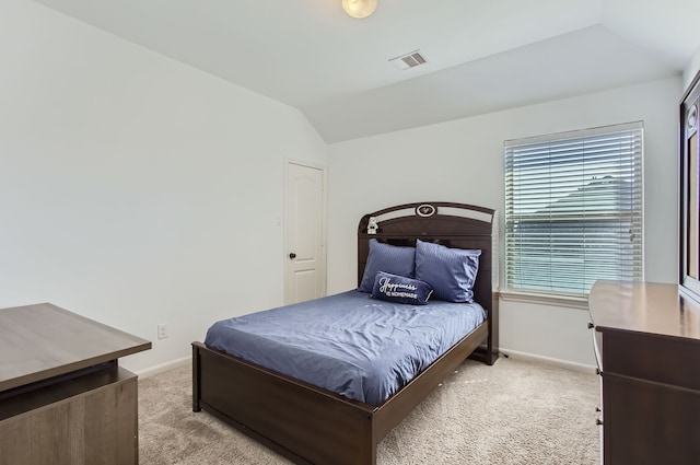 bedroom with lofted ceiling and light colored carpet