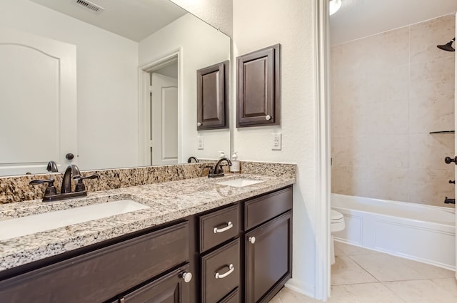 full bathroom with toilet, tiled shower / bath, vanity, and tile patterned flooring