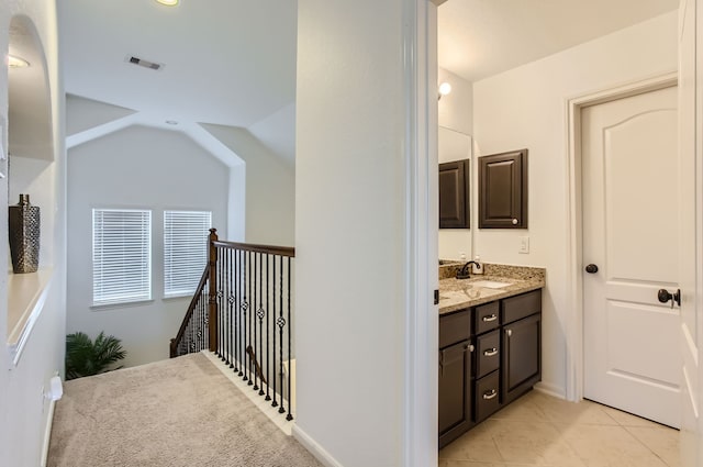 bathroom with vanity, lofted ceiling, and tile patterned flooring