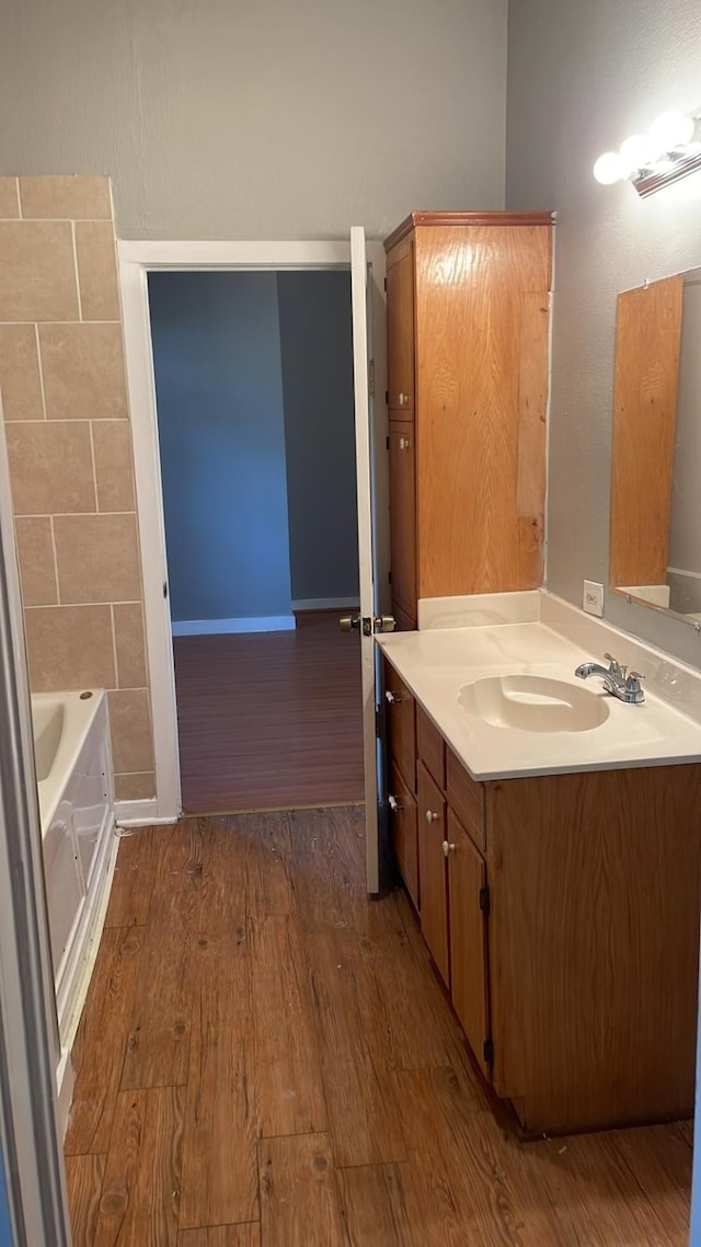 bathroom featuring vanity, a bathtub, and wood-type flooring