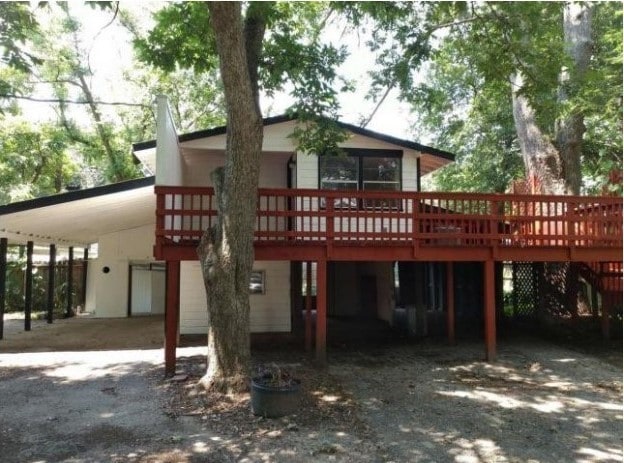 back of property with a carport and a deck