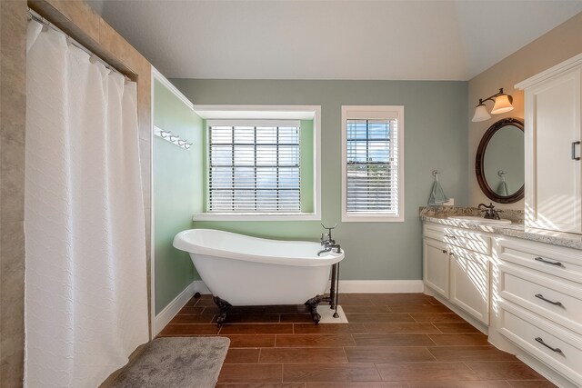 bathroom with vanity, hardwood / wood-style flooring, and a bathing tub