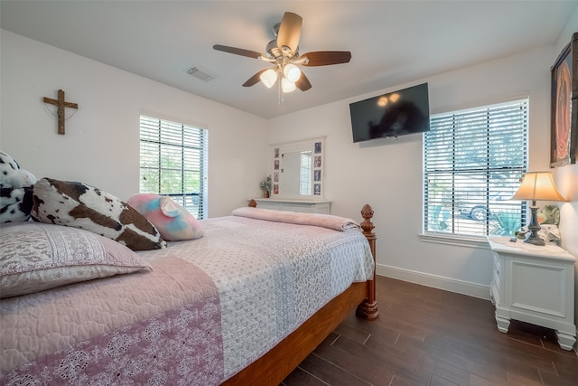 bedroom featuring dark wood-type flooring, multiple windows, and ceiling fan