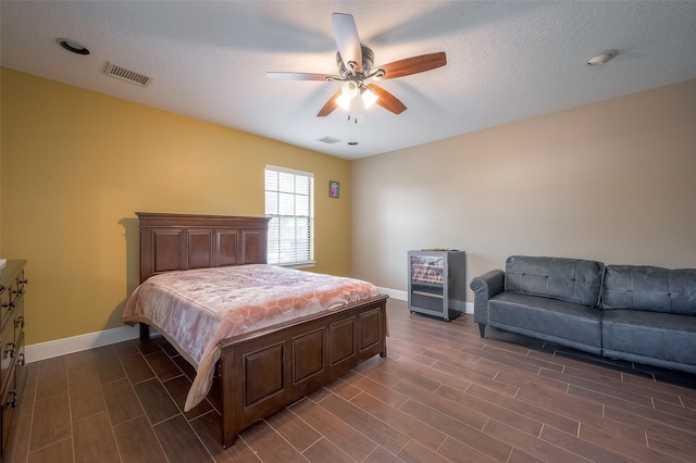 bedroom featuring a textured ceiling, dark hardwood / wood-style floors, and ceiling fan