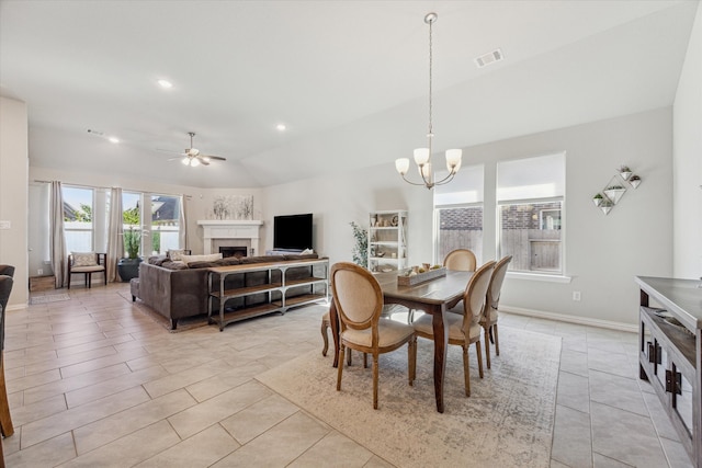 tiled dining room featuring vaulted ceiling and ceiling fan with notable chandelier