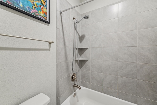 bathroom with toilet and tiled shower / bath combo