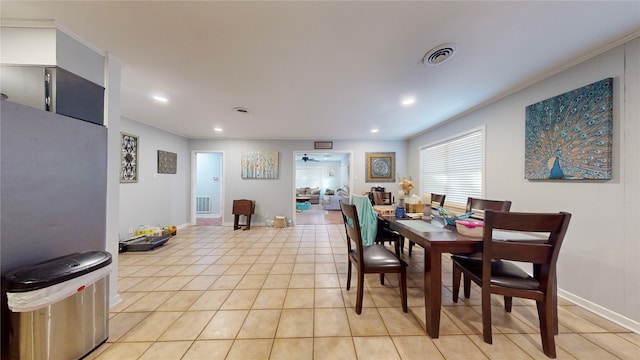 dining space featuring crown molding and light tile patterned floors