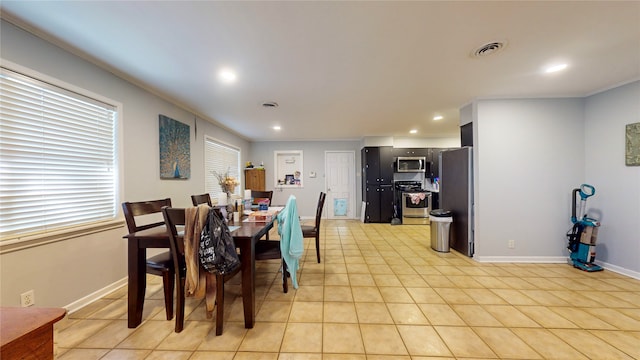 tiled dining area featuring crown molding