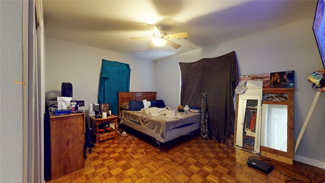 bedroom featuring ceiling fan and dark parquet flooring