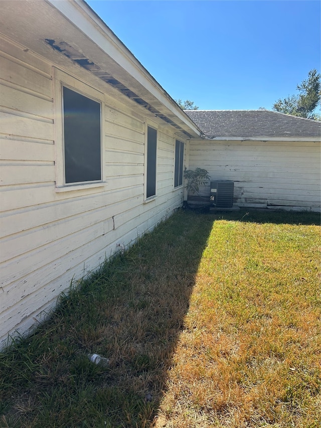 view of property exterior with a lawn and cooling unit