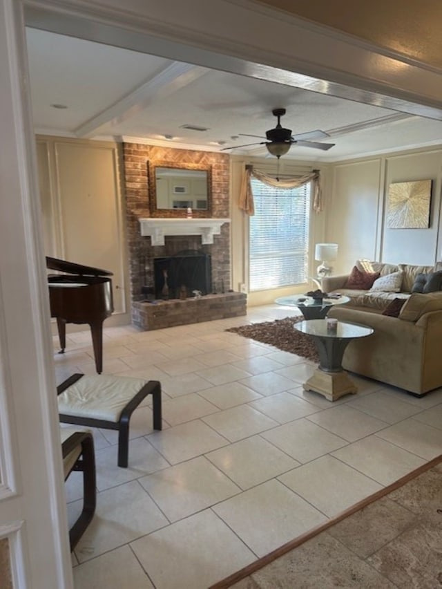 living area featuring crown molding, ceiling fan, a fireplace, and beamed ceiling