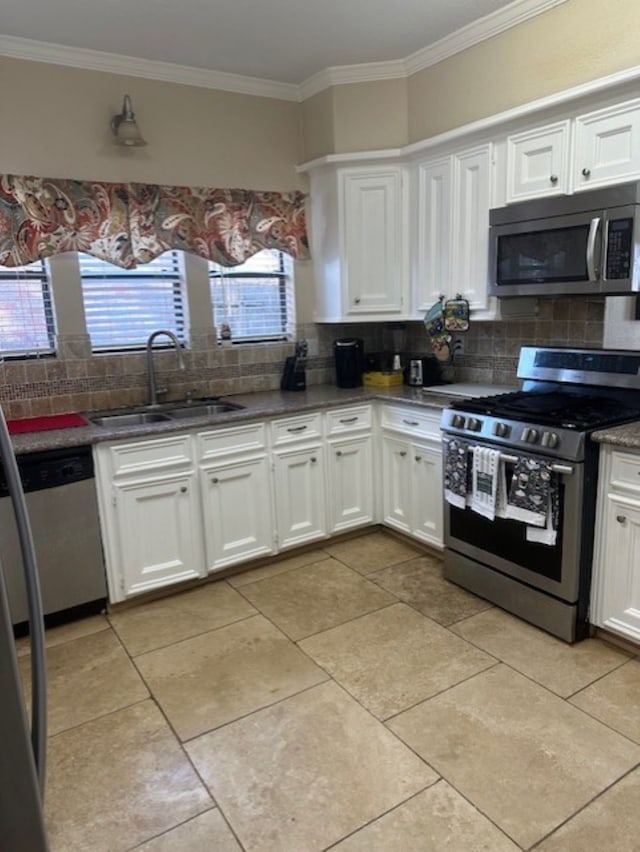 kitchen featuring a sink, tasteful backsplash, stainless steel appliances, and white cabinets