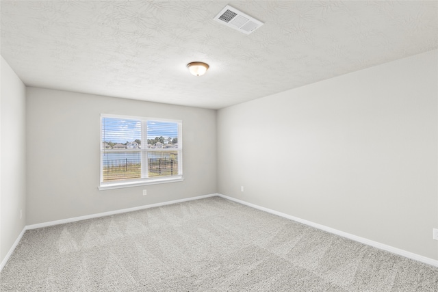 empty room with carpet and a textured ceiling